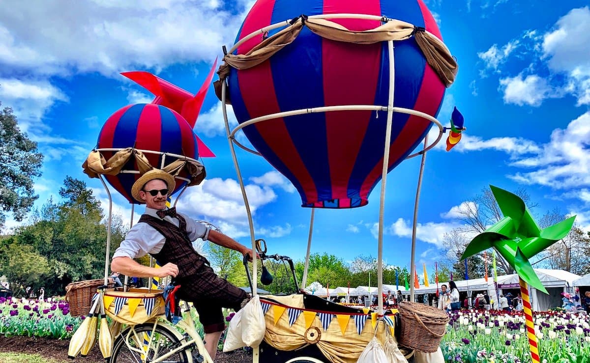 Balloon bike performers in a colourful outdoor setting